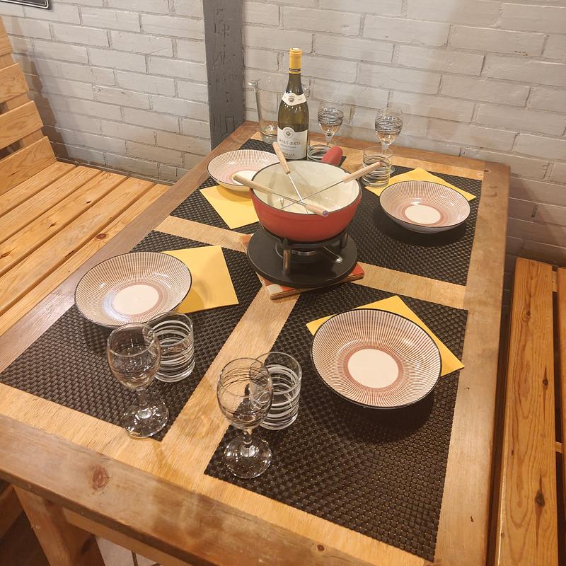 Table dressée pour quatre autour d'un caquelon à fondue