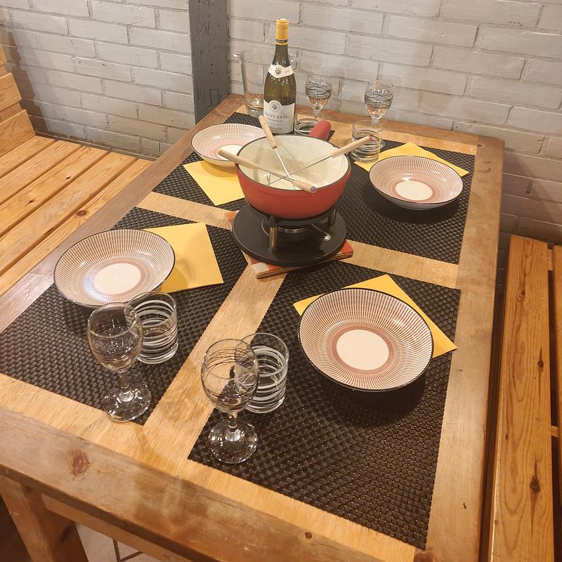 Une table dressée autour d'un caquelon à fondue